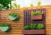 Sadolin Quick Dry Woodstain Lifestyle - brown stained wood in a garden setting with potted plants.