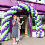 Niamh Rogers and Josie Rogers at the Anniversary event - standing at the store front under a balloon arch